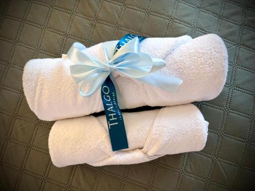 a stack of towels with a blue bow on top at Boutique Provincja Winebar & Rooms in Olsztyn