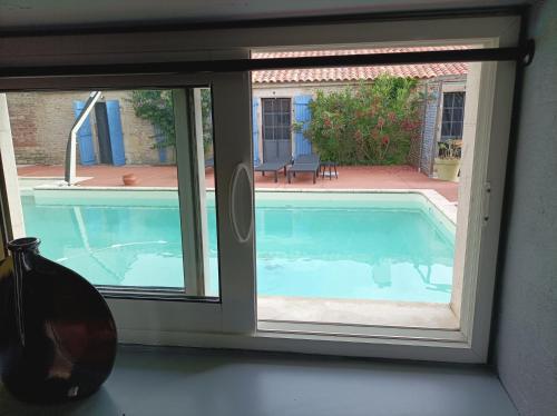 une fenêtre avec vue sur la piscine dans l'établissement Gîte Jazz - La note Bleue, à Sainte-Radégonde-des-Noyers