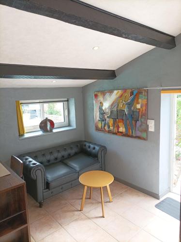 - un salon avec un canapé et un tableau dans l'établissement Gîte Jazz - La note Bleue, à Sainte-Radégonde-des-Noyers