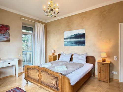 a bedroom with a bed and a chandelier at Ferienwohnung Seeperle49 - Besonders, stilvoll mit eigenem Badestrand in Nonnenhorn