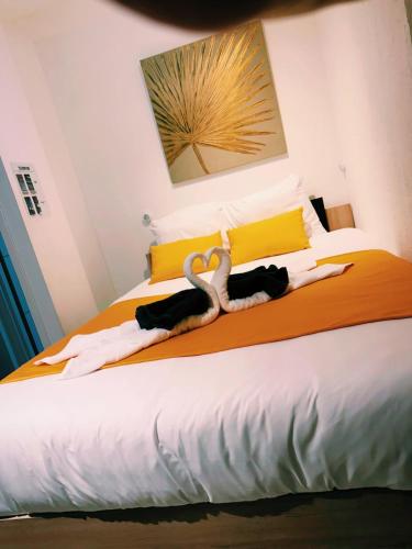 un lit avec deux cygnes posés sur lui dans l'établissement Duplex Citadin 6-8 pers - Coeur de Ville - Parking, à Béziers