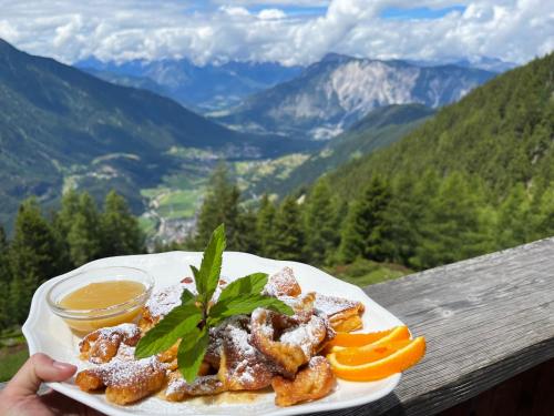 a plate of food on a table with a view of mountains at Die Acherberg Alm in Oetz