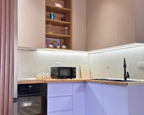 a kitchen with a sink and a microwave at Azalea Apartment in Durrës