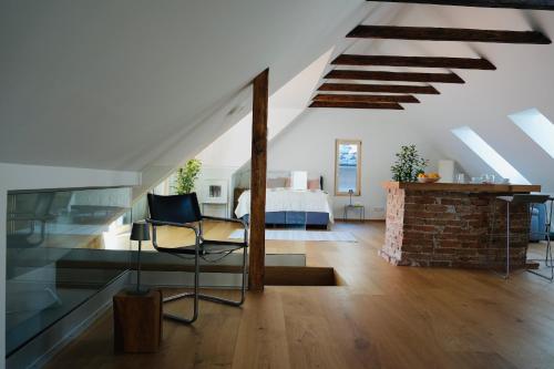 a bedroom with a bed and a chair in a room at Exklusive Dachgeschoß-Suite mit Sauna & Terrasse in Waidhofen an der Ybbs