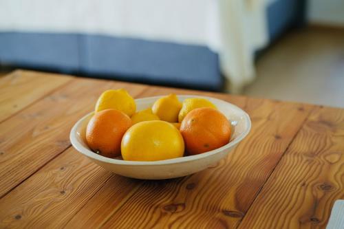 a bowl of oranges and lemons on a wooden table at Exklusive Dachgeschoß-Suite mit Sauna & Terrasse in Waidhofen an der Ybbs