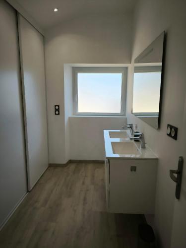 une salle de bain avec un lavabo et un miroir dans l'établissement Stagadenn, à Camors