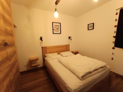 - une chambre dotée d'un lit avec des draps blancs dans l'établissement Résidence Loup Argente - Superbe appartement luxe - Terrasse - Sud MAE-8384, à Montgenèvre