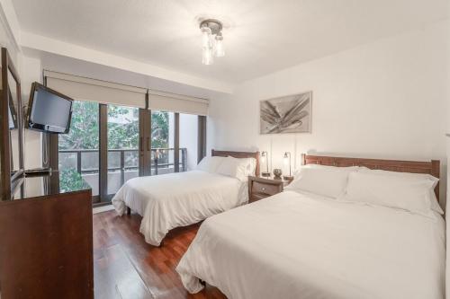 um quarto com 2 camas, uma televisão e uma janela em Miami Beach Oceanfront- Pool Bar & Gym & SPA em Miami Beach