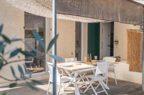Une table à manger et des chaises sont disponibles sur la terrasse. dans l'établissement Antibes Secret Garden, à Antibes