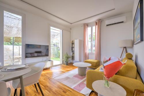 un salon avec un canapé jaune et une table dans l'établissement Antibes Secret Garden, à Antibes