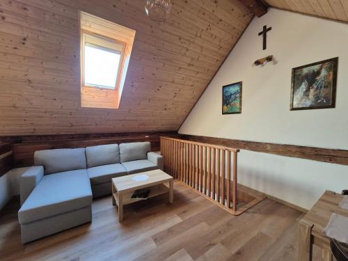 a living room with a couch and a cross on the wall at Apartmán Andrea in Hrabušice