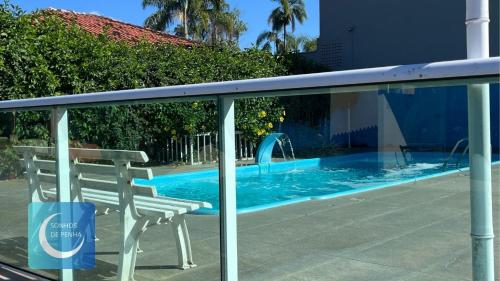 a swimming pool with a chair and a water slide at Sonhos de Penha - Chalés e Aptos in Penha