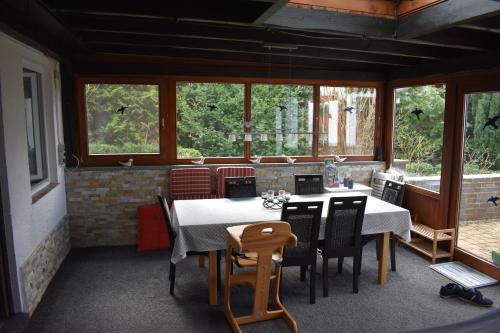 a dining room with a table and chairs and windows at Ferienhaus Bella Vista Edersee in Vöhl