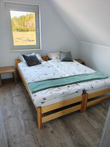 a bed in a room with a window at Domek letniskowy nad morzem in Osieki Leborskie