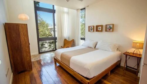 a bedroom with a bed and a large window at Soluna Tulum in Tulum