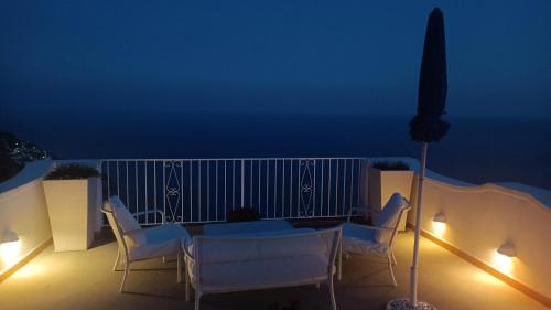 a table and chairs on a balcony at night at Villa Antica Macina in Positano