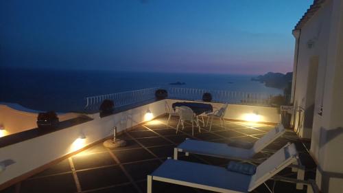 a balcony with a view of the ocean at night at Villa Antica Macina in Positano