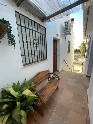 a wooden bench sitting on a patio next to a building at Zuchar in Granada