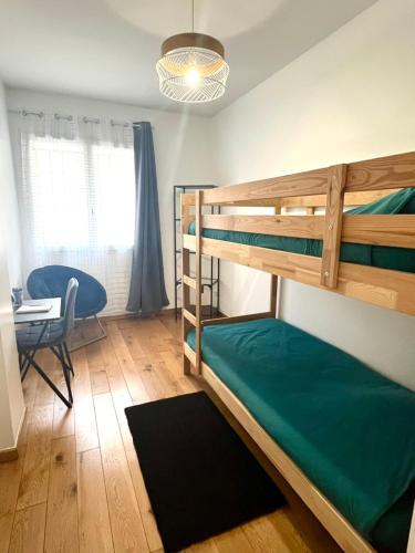 une chambre avec deux lits superposés et un bureau dans l'établissement Charmant appartement 3 pièces, à Paris