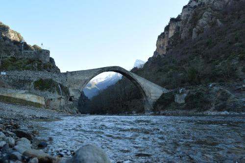 a bridge over a river next to a mountain at Potamolithos Suites 2 in Konitsa