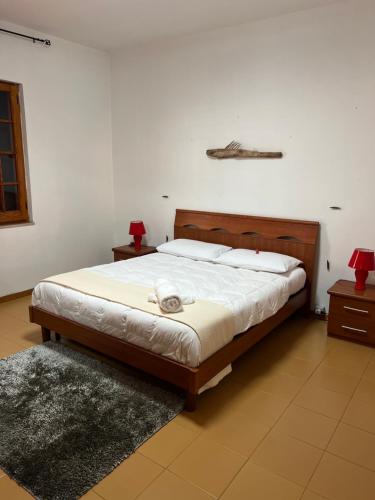 a bedroom with a large bed with white sheets at Casa Maestrale in Gonnesa