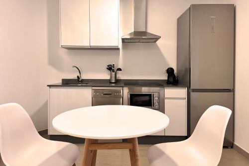 a small kitchen with a white table and chairs at Complejo Turístico El Oasis de San José in San José