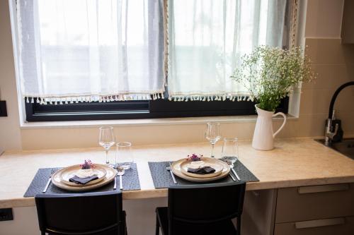 a table with two plates and wine glasses on it at The Boho Breeze Studio in Kos Town