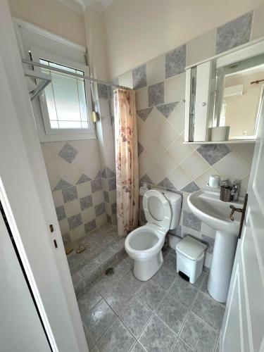 a bathroom with a toilet and a sink at Komi's Pink Paradise 1 in Kómi