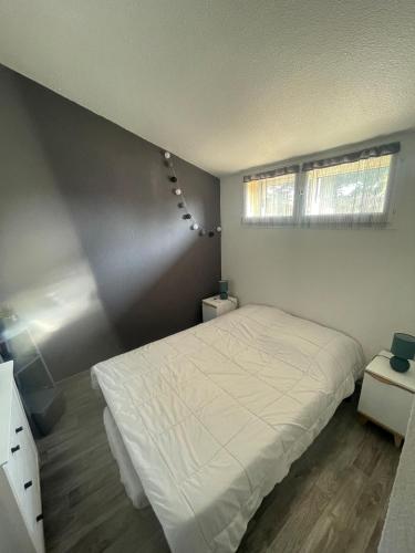 - une chambre avec un lit blanc et 2 fenêtres dans l'établissement Maisonnette cosy piscine parking, à Argelès-sur-Mer