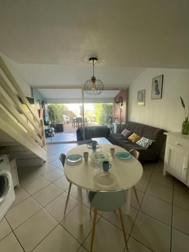 un salon avec une table et un canapé dans l'établissement Maisonnette cosy piscine parking, à Argelès-sur-Mer