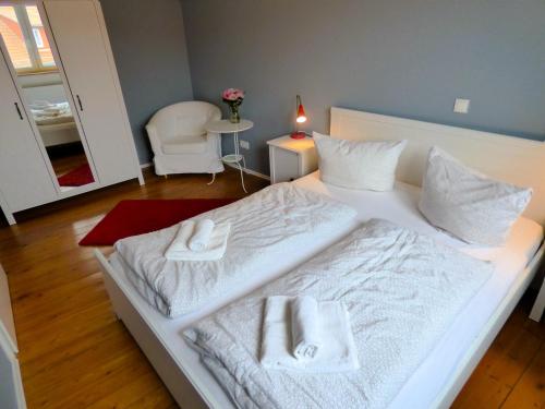 a bedroom with a white bed with towels on it at Emely Ferienwohnungen in Röbel