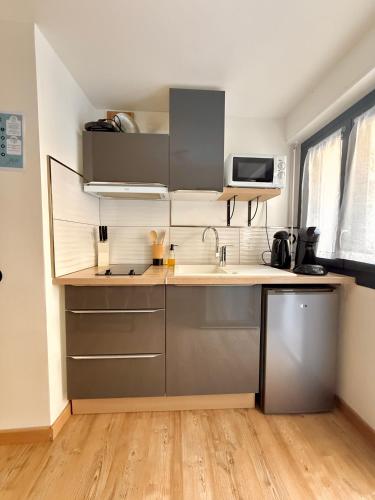 une cuisine avec un évier et un micro-ondes dans l'établissement Studio Cœur de Moustiers - Terrasse, à Moustiers-Sainte-Marie