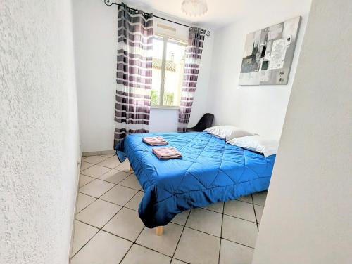 - une petite chambre avec une couette bleue sur un lit dans l'établissement Villa Le Jardin des Délices - de 2 à 8 personnes avec Piscine, à Raissac-dʼAude