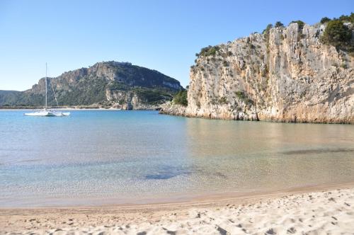 a sandy beach with a boat in the water at appartement lena in Messini