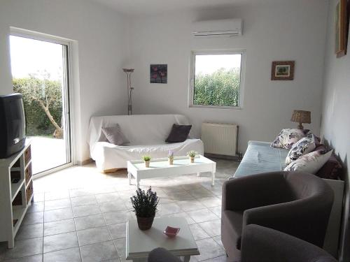 a living room with a couch and a tv at appartement lena in Messini