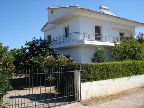 a white house with a fence in front of it at appartement lena in Messini