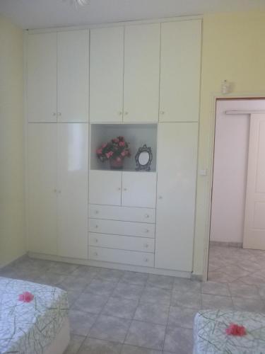 a bedroom with a large white cabinet with a clock at appartement lena in Messini