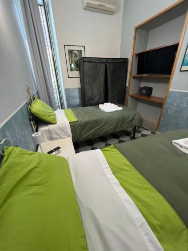 two beds in a room with green and white at Bell'e Buono vicino aeroporto di Capodichino in Naples