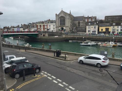 two cars parked on a street next to a river at Sailors Return Weymouth in Weymouth