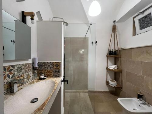 un bagno con vasca, lavandino e doccia di La suite del Marchese a Vieste a Vieste