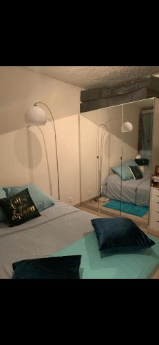 une chambre avec un lit et un grand miroir dans l'établissement Le Havre Saintprio, à Saint-Priest