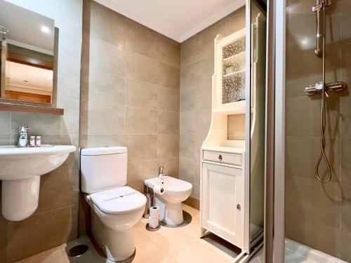 a bathroom with a toilet and a sink and a shower at Apartamento Olmeca - Monabri in Santander