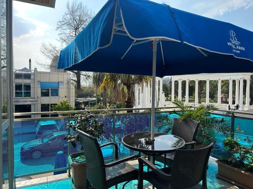 a table and chairs under an umbrella next to a pool at Hotel Park in Batumi