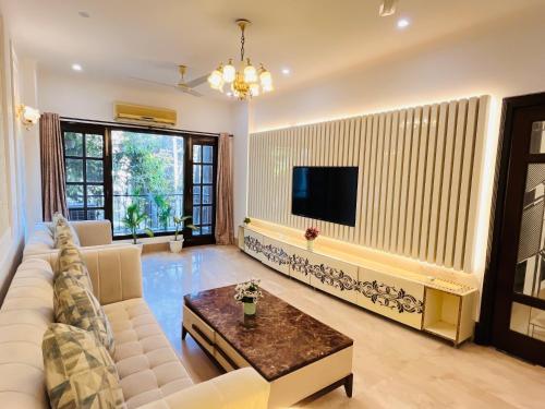 a living room with a couch and a tv at The South Manor Residency Near AIIMS Hospital New Delhi in New Delhi