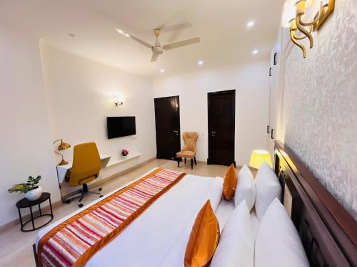 a bedroom with a bed and a desk and a tv at The South Manor Residency Near AIIMS Hospital New Delhi in New Delhi