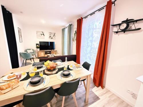 une salle à manger avec une table et des chaises en bois dans l'établissement Duplex Citadin 6-8 pers - Coeur de Ville - Parking, à Béziers