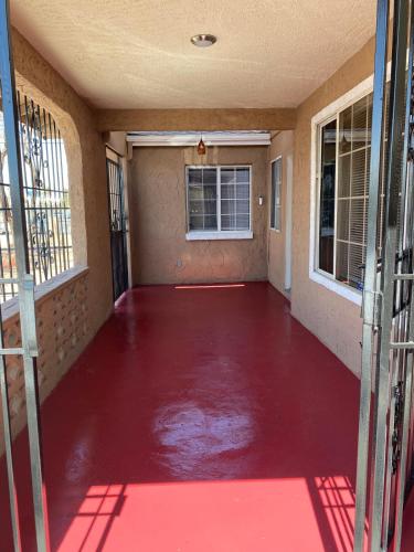 an empty room with a red floor and windows at Vegas Oasis- Modern Getaway 5 mins from Strip in Las Vegas