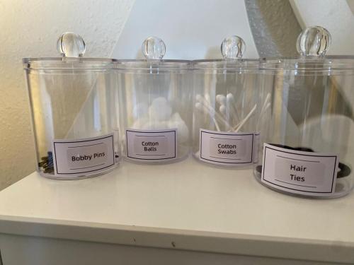 a shelf with four labels on a glass container at Vegas Oasis- Modern Getaway 5 mins from Strip in Las Vegas