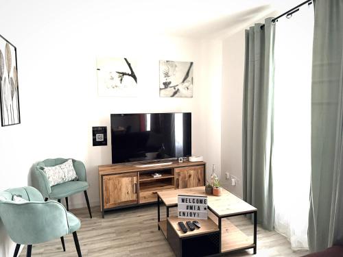 un salon avec une télévision et une table dans l'établissement Duplex Citadin 6-8 pers - Coeur de Ville - Parking, à Béziers