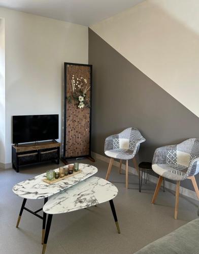 a living room with two chairs and a table at Part des Anges - Gîte Hautvillers in Hautvillers